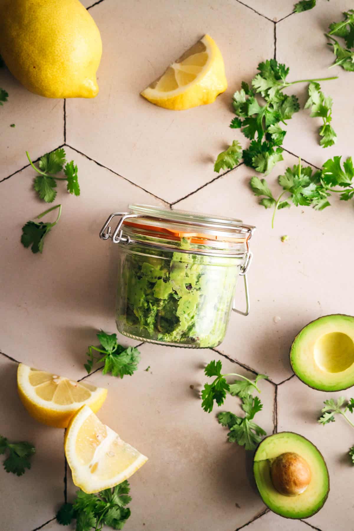 Sealing a glass jar full of the best guacamole recipe.
