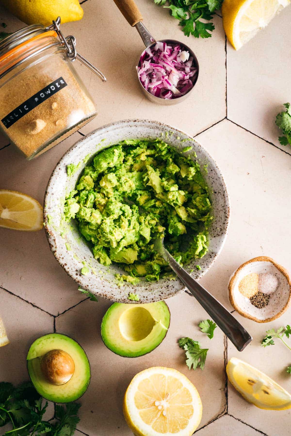 Mashing fresh avocado in a bowl for homemade guacamole.