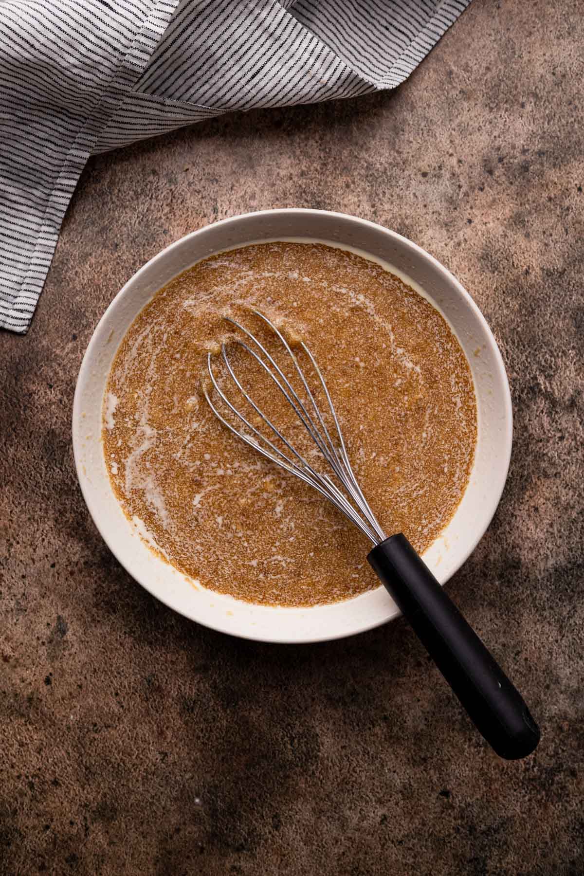 Combining the wet ingredients for banana pecan muffins.