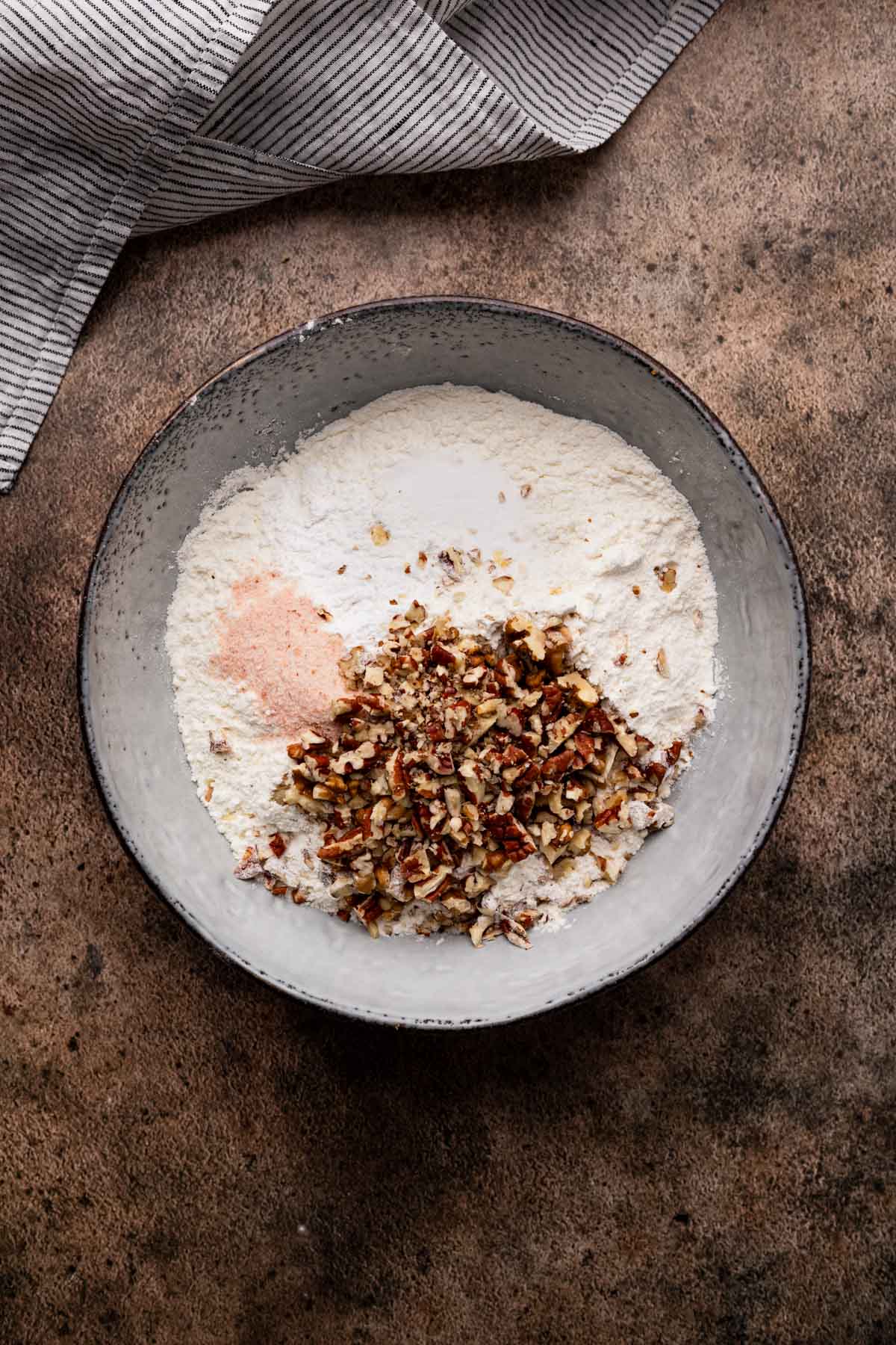 Mixing the dry ingredients for banana muffins with pecans.