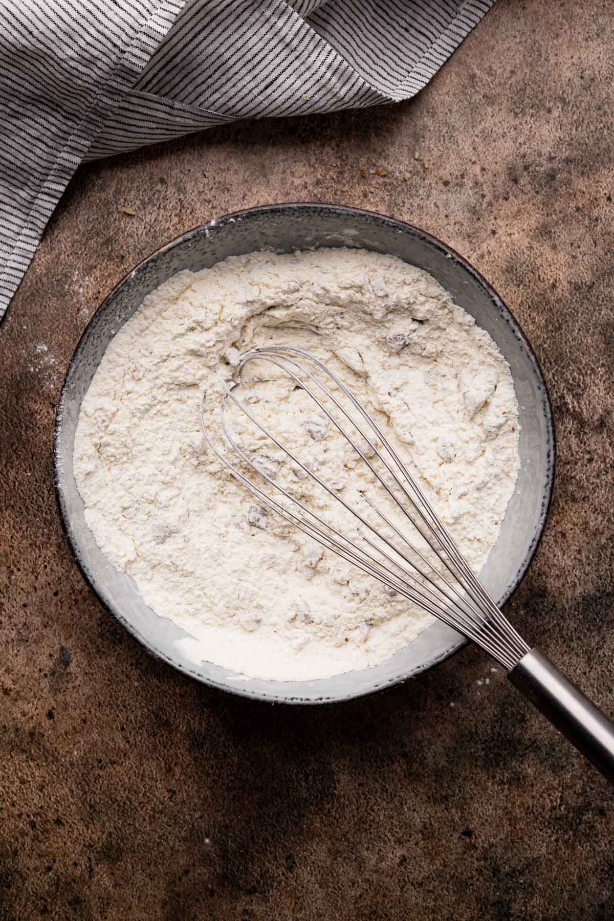 Mixing the dry ingredients for banana muffins with pecans.