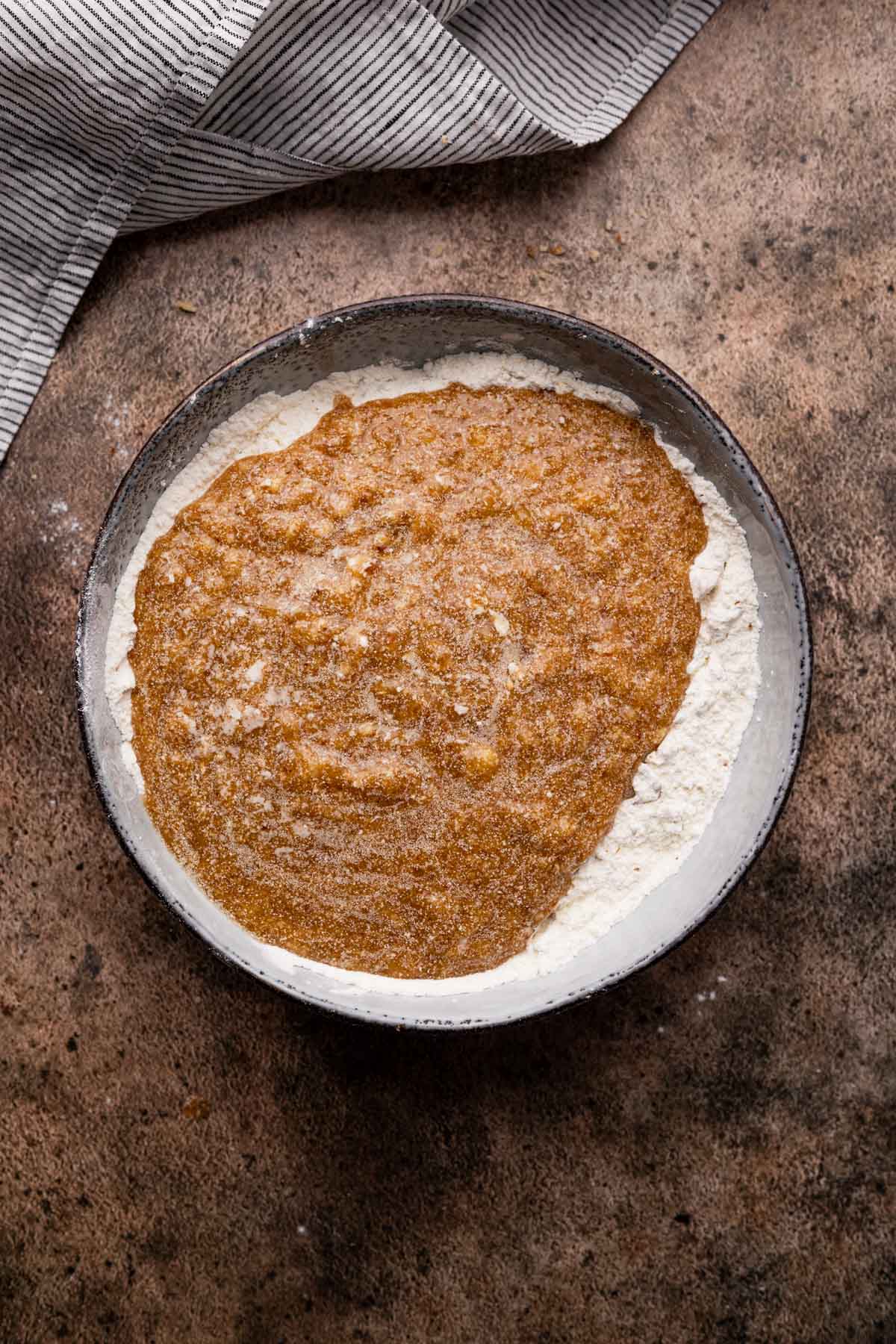 Combining dry and wet ingredients together for easy pecan banana muffins.