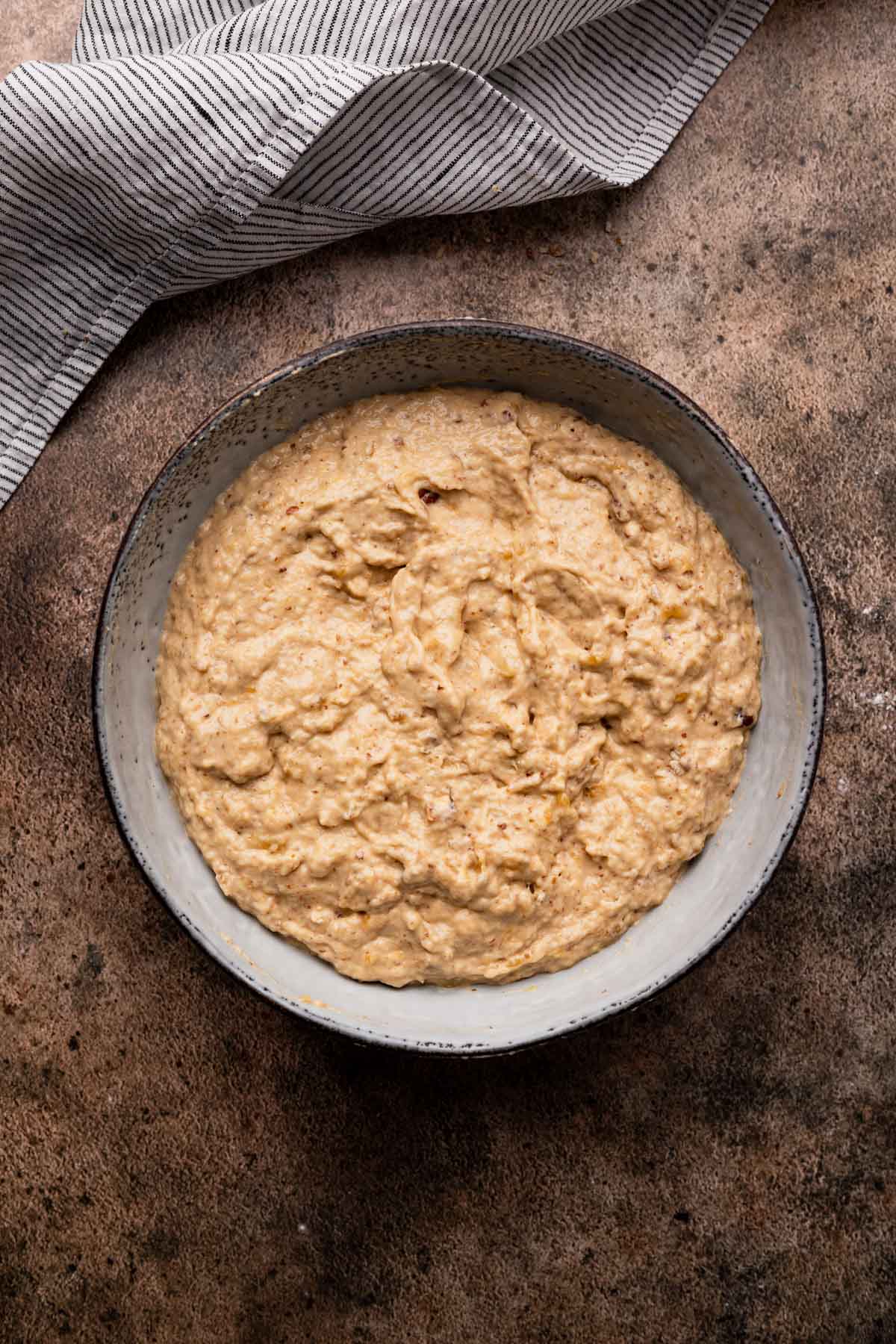 Combining dry and wet ingredients together for easy pecan banana muffins.