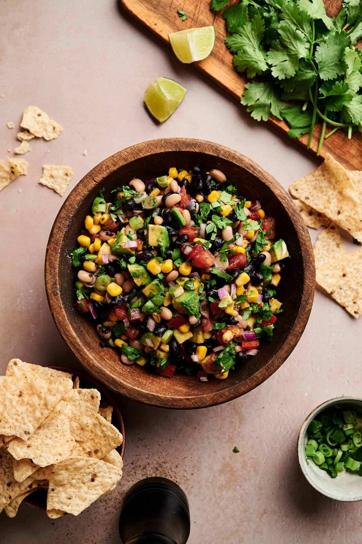 Healthy cowboy caviar on a cream counter with fresh ingredients next to it.