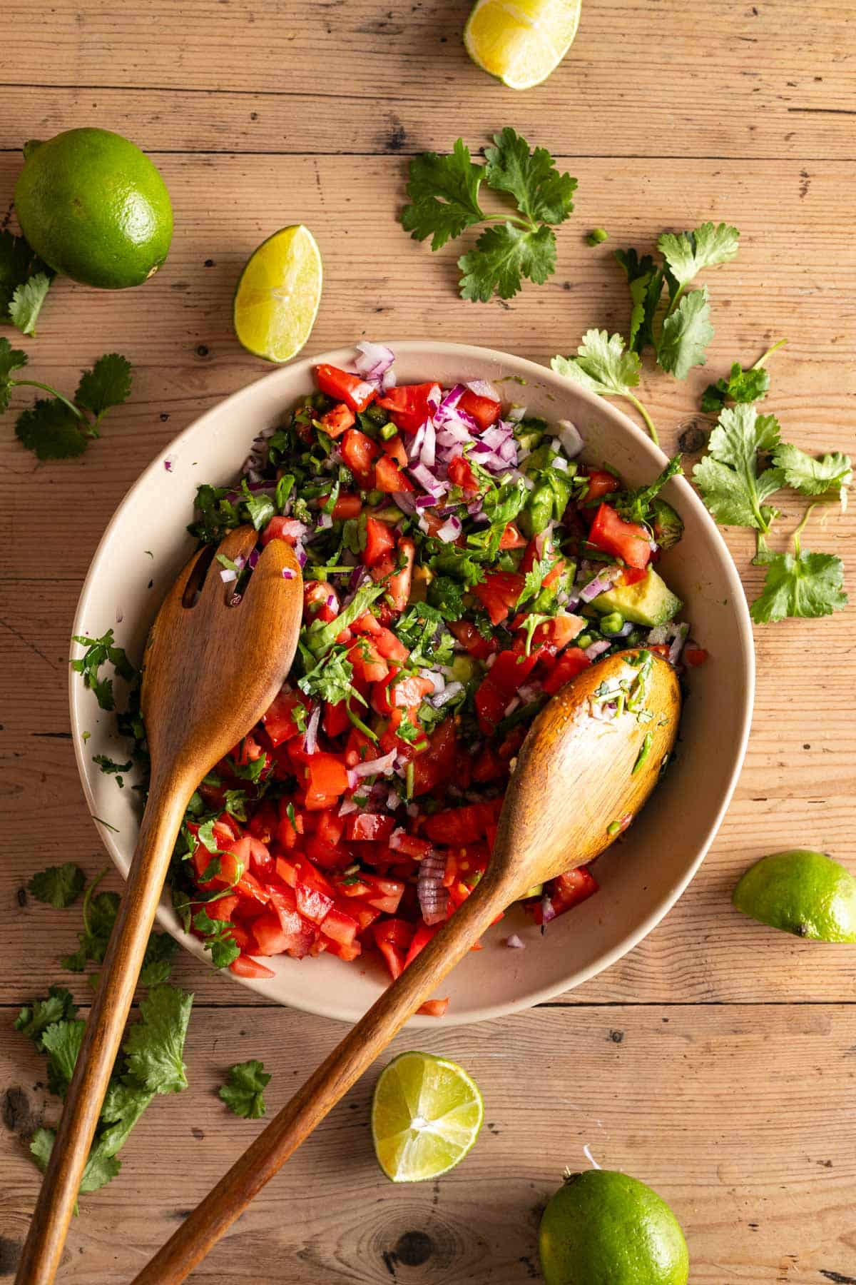 Mixing all the ingredients for pico de gallo with cubed avocado.