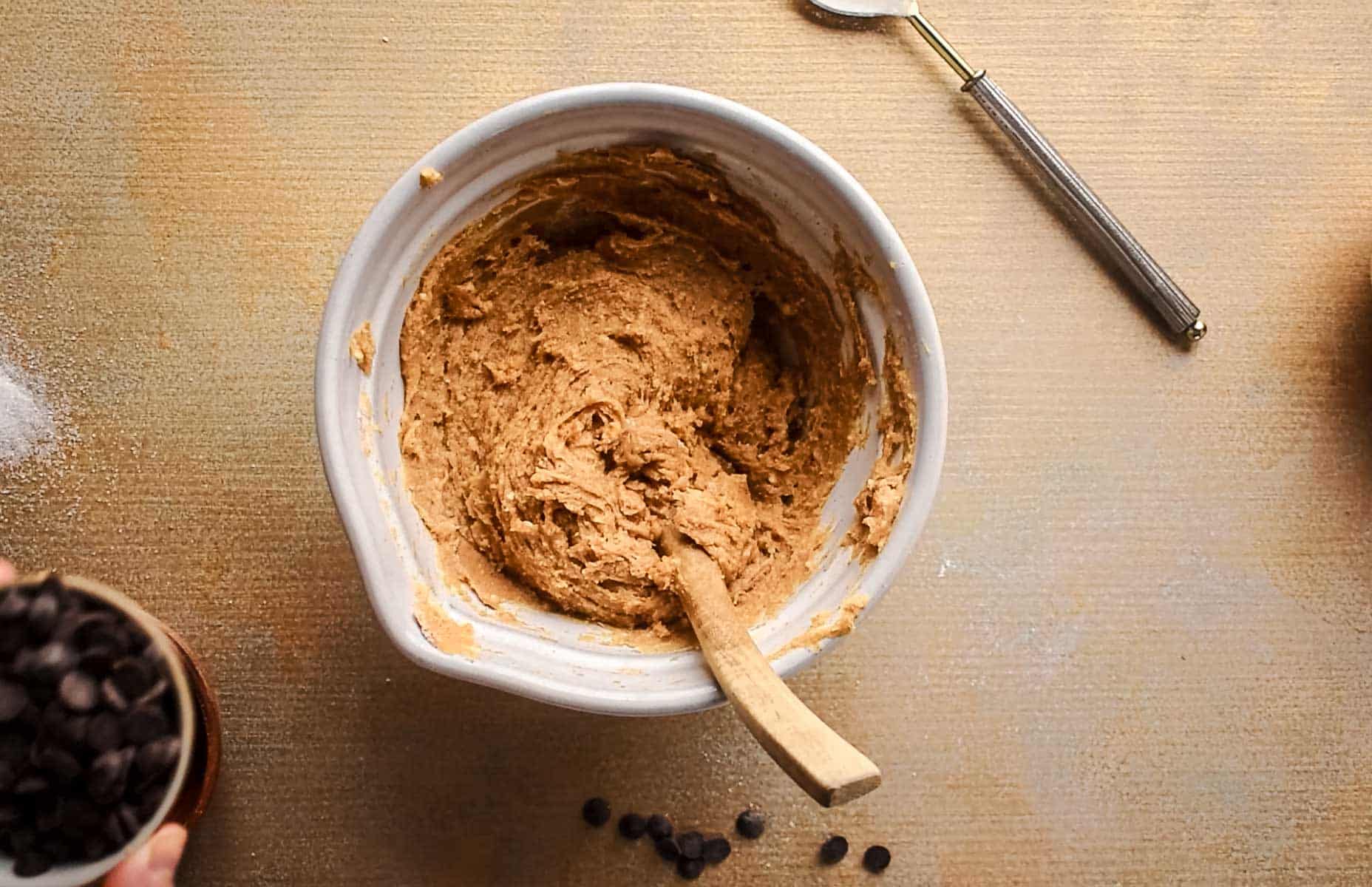 Combining the dry and wet ingredients in a large ceramic mixing bowl.
