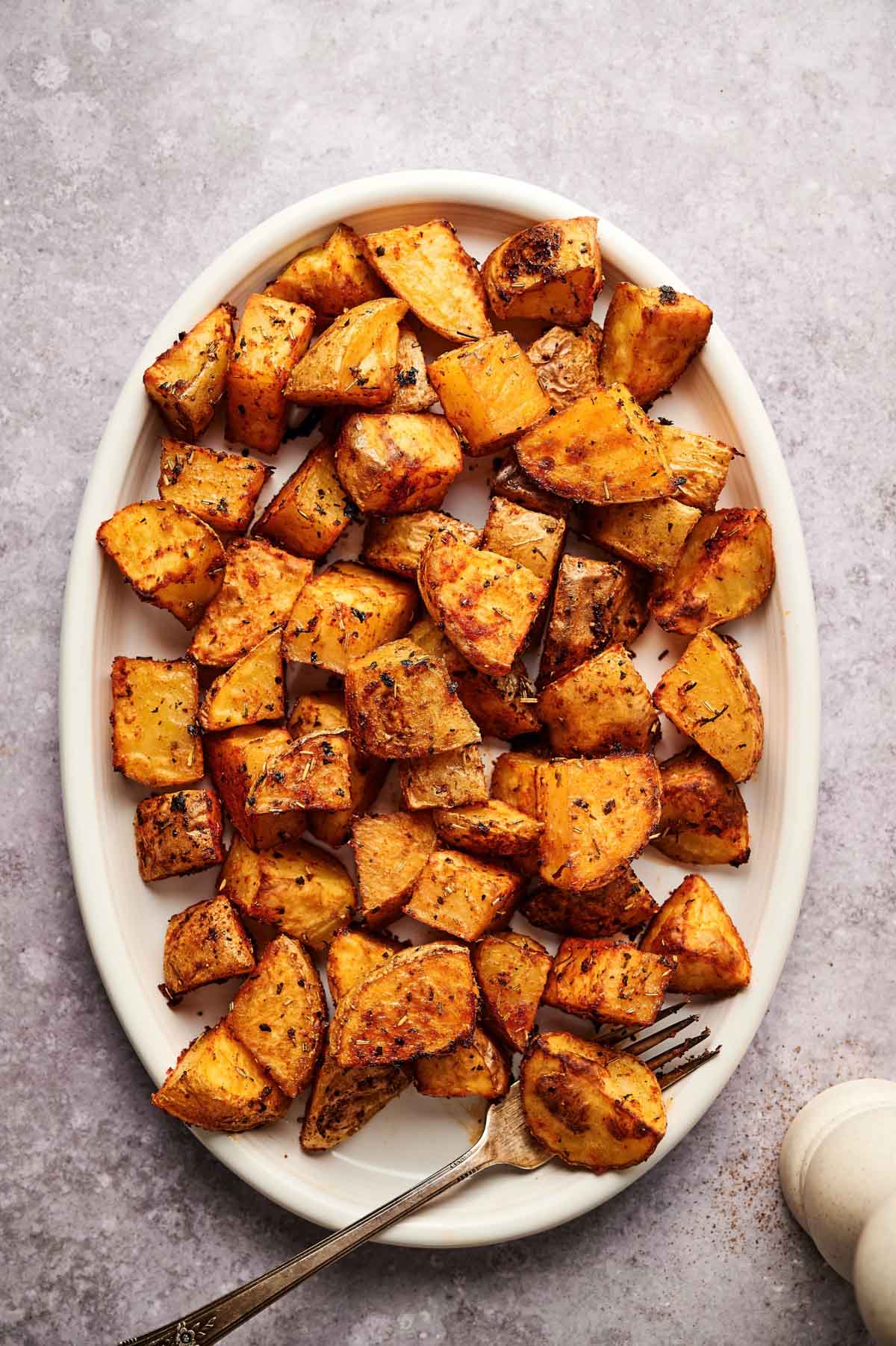 Oval plate of oven baked home fries.