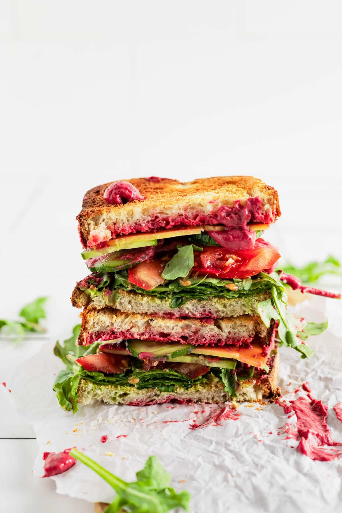 Hummus beet sandwich cut in half and stacked onto each other.