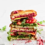 Hummus beet sandwich cut in half and stacked onto each other.