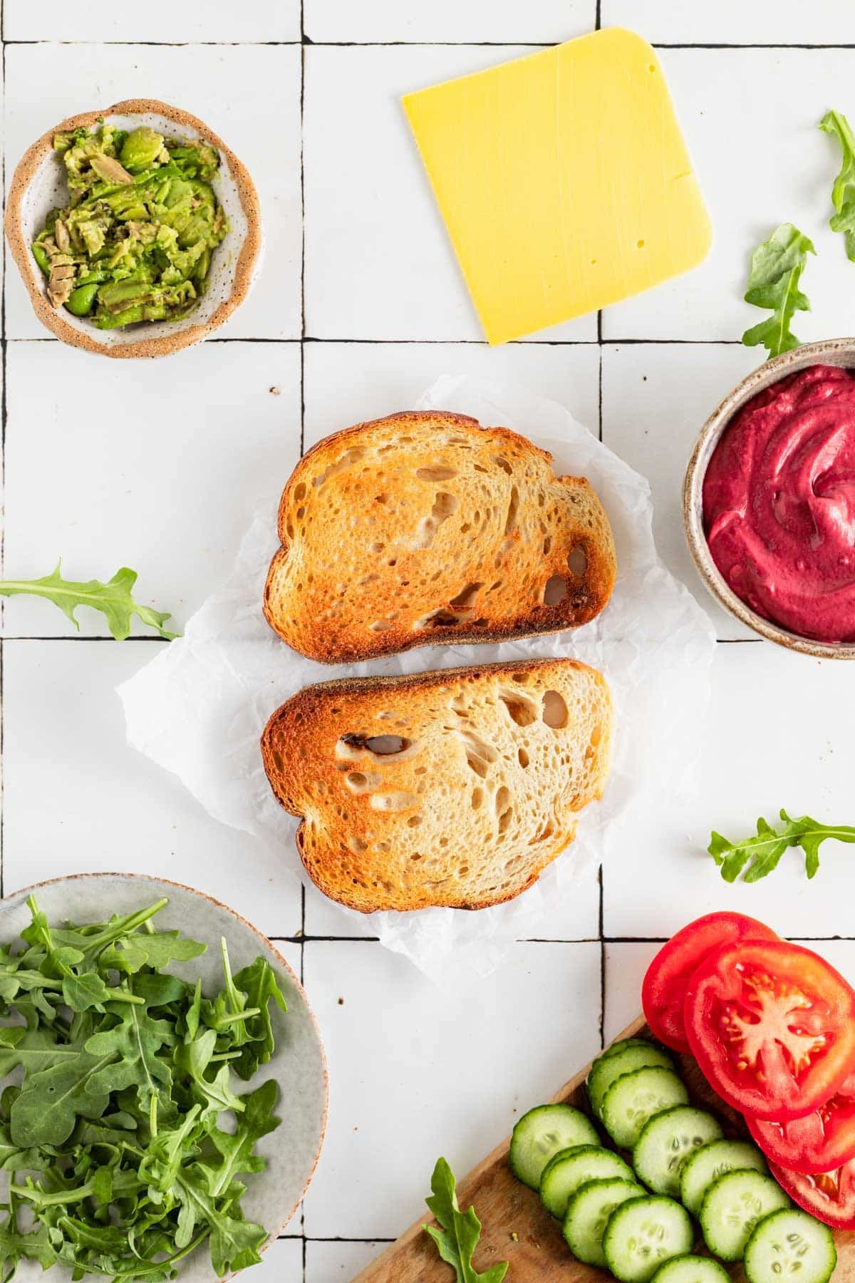 Ingredients for beetroot sandwich on white tile counter.