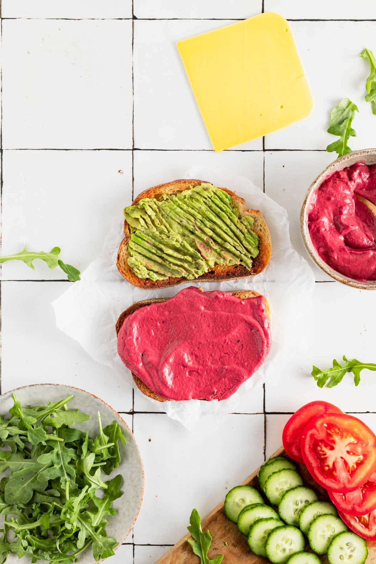 Mashing avocado and spreading it on one slide of toasted bread.