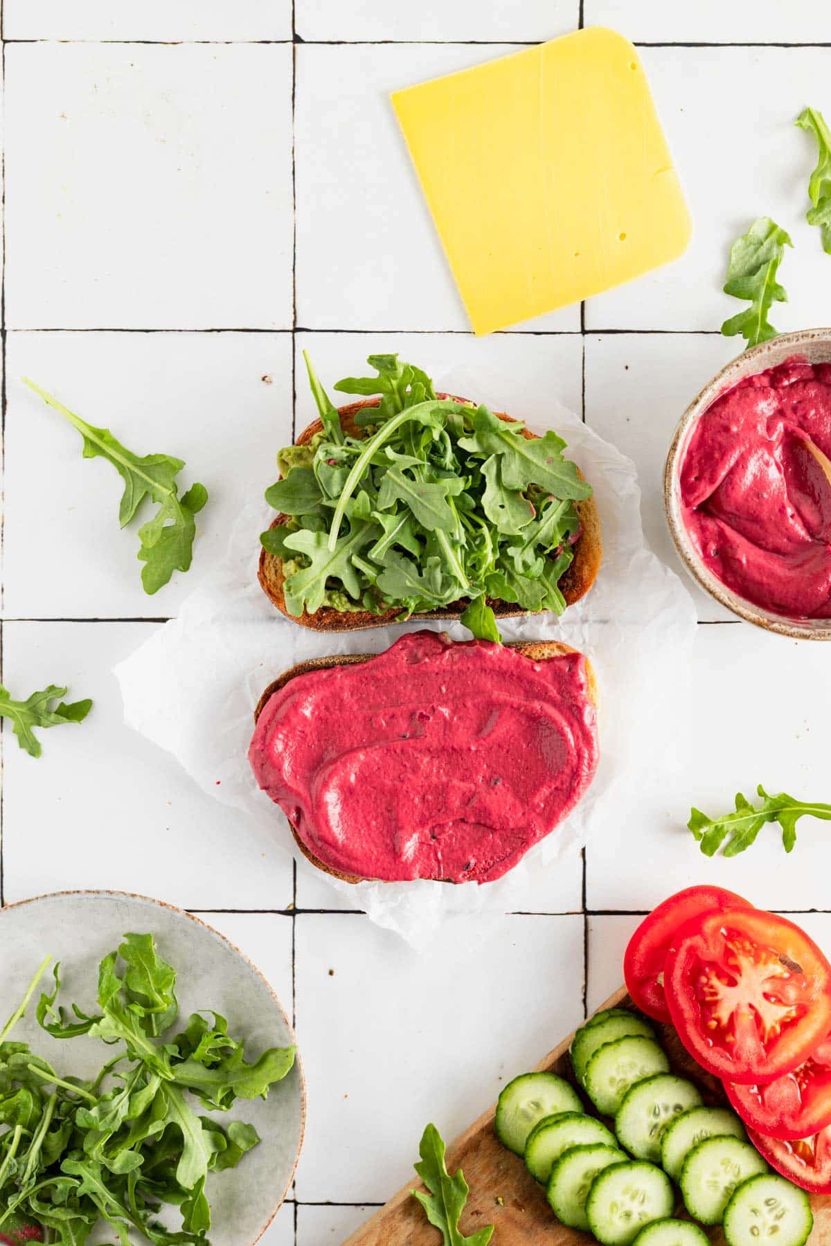 Adding veggies to a vegetable beetroot sandwich.