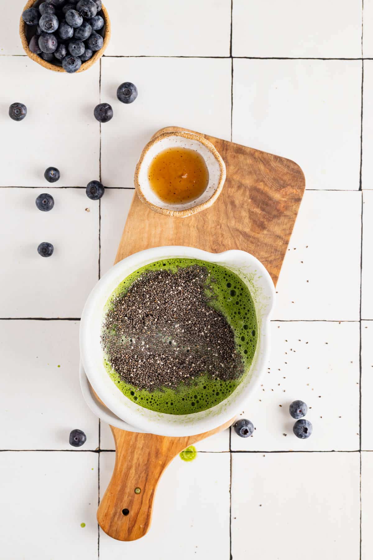 Matcha, chia seeds, and maple syrup in a bowl.
