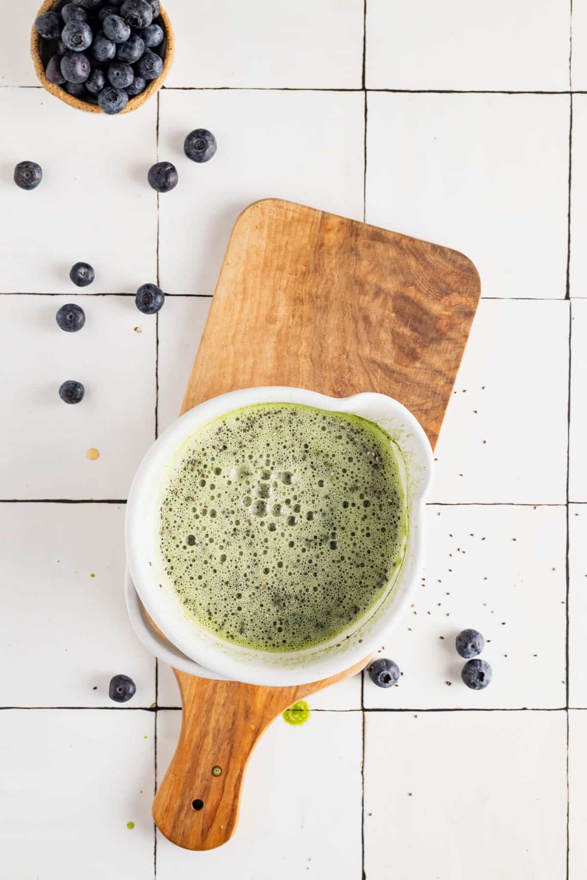 Ingredients for matcha chia seed pudding in a bowl mixed together.