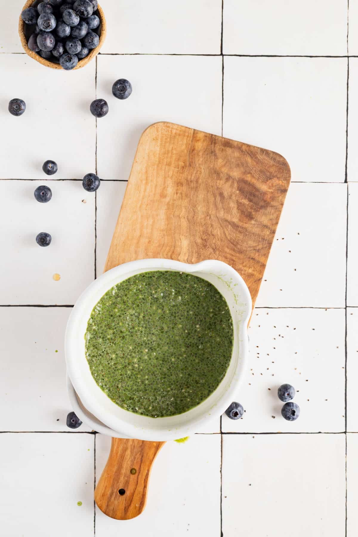 Matcha chia pudding mixed together and soaked in a small white bowl.