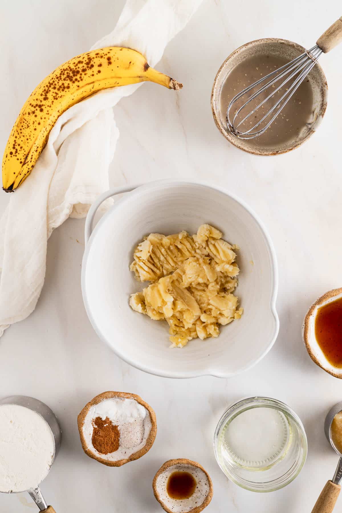Mashing a banana in a bowl for mini banana bread muffins.