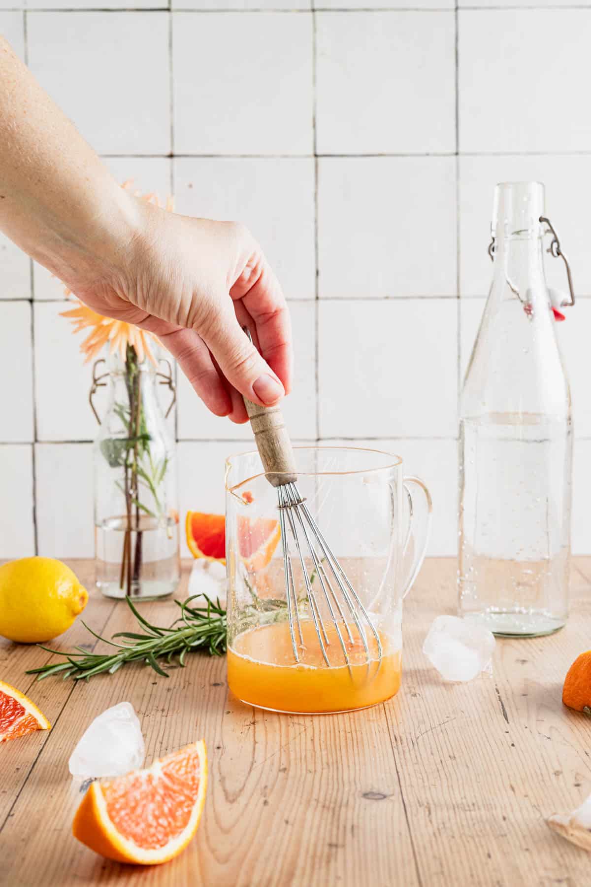 Whisking a citrus mocktail in a liquid measuring cup.