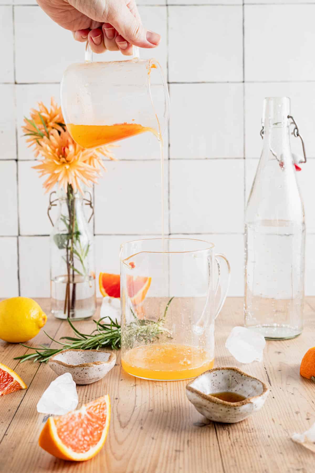 Pouring fresh squeezed orange and lemon juice into a liquid measuring cup.