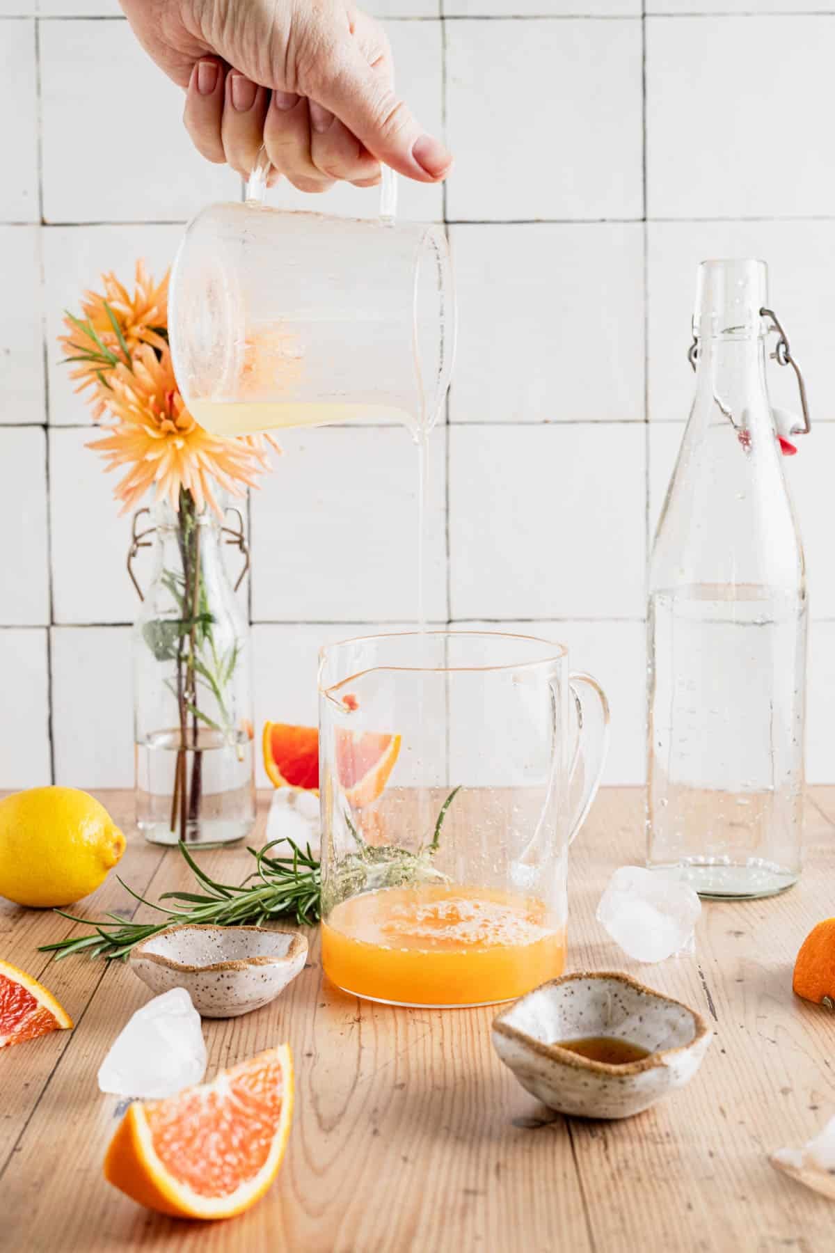 Pouring fresh squeezed orange and lemon juice into a liquid measuring cup.