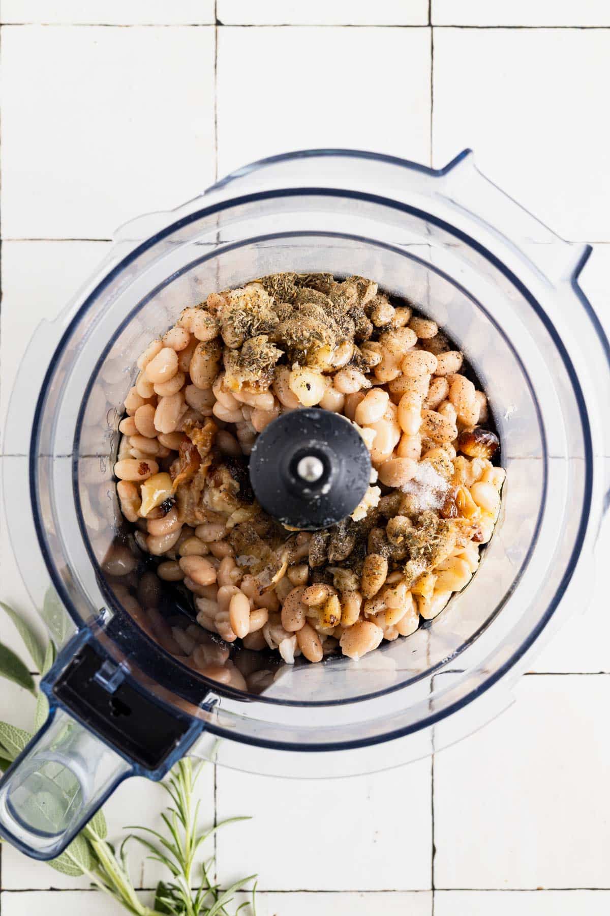 Ingredients for Italian white bean dip in a food processor.