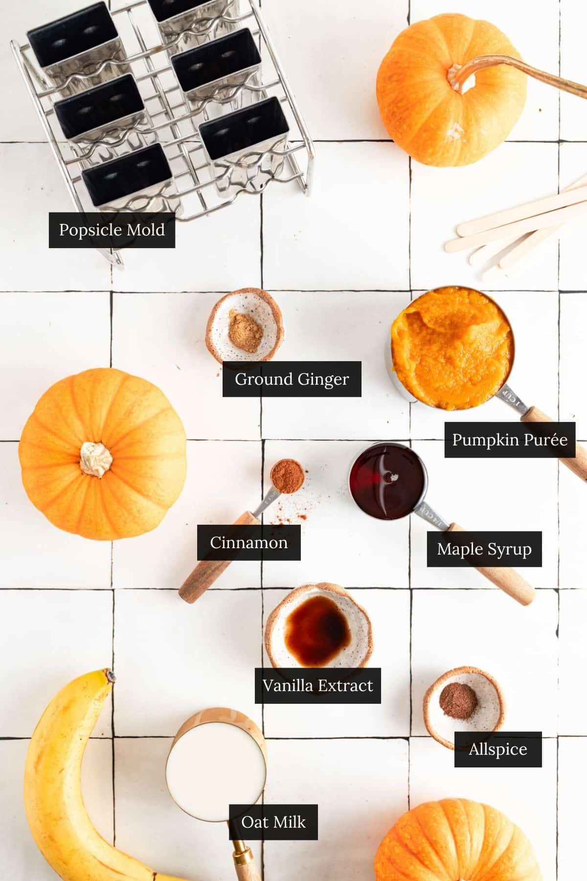 Ingredients for pumpkin pie popsicles on a white tile counter with each ingredient labeled.