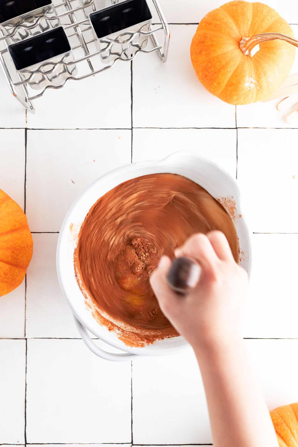Whisking all the ingredients for pumpkin popsicles together.