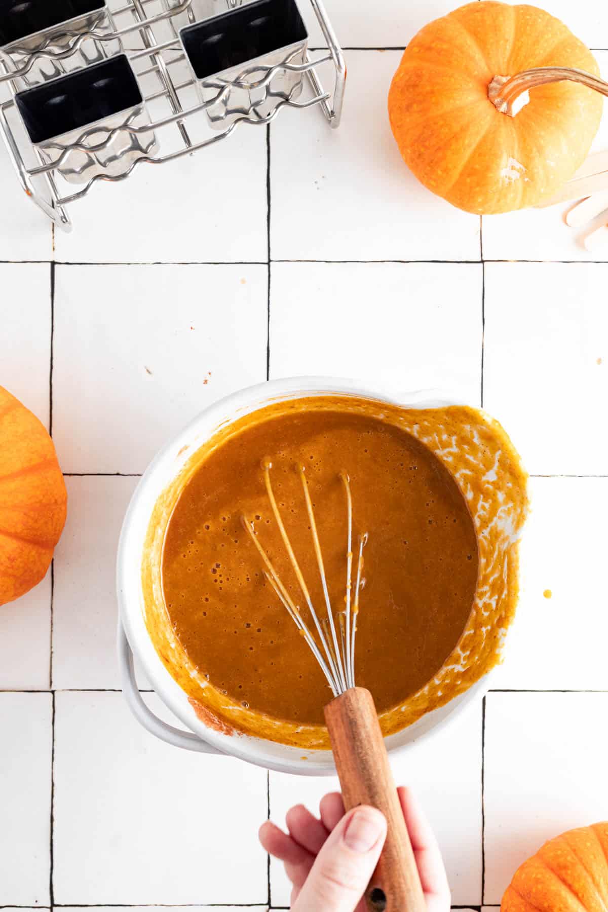 Pumpkin spice popsicles in a mixing bowl with a whisk sticking out.