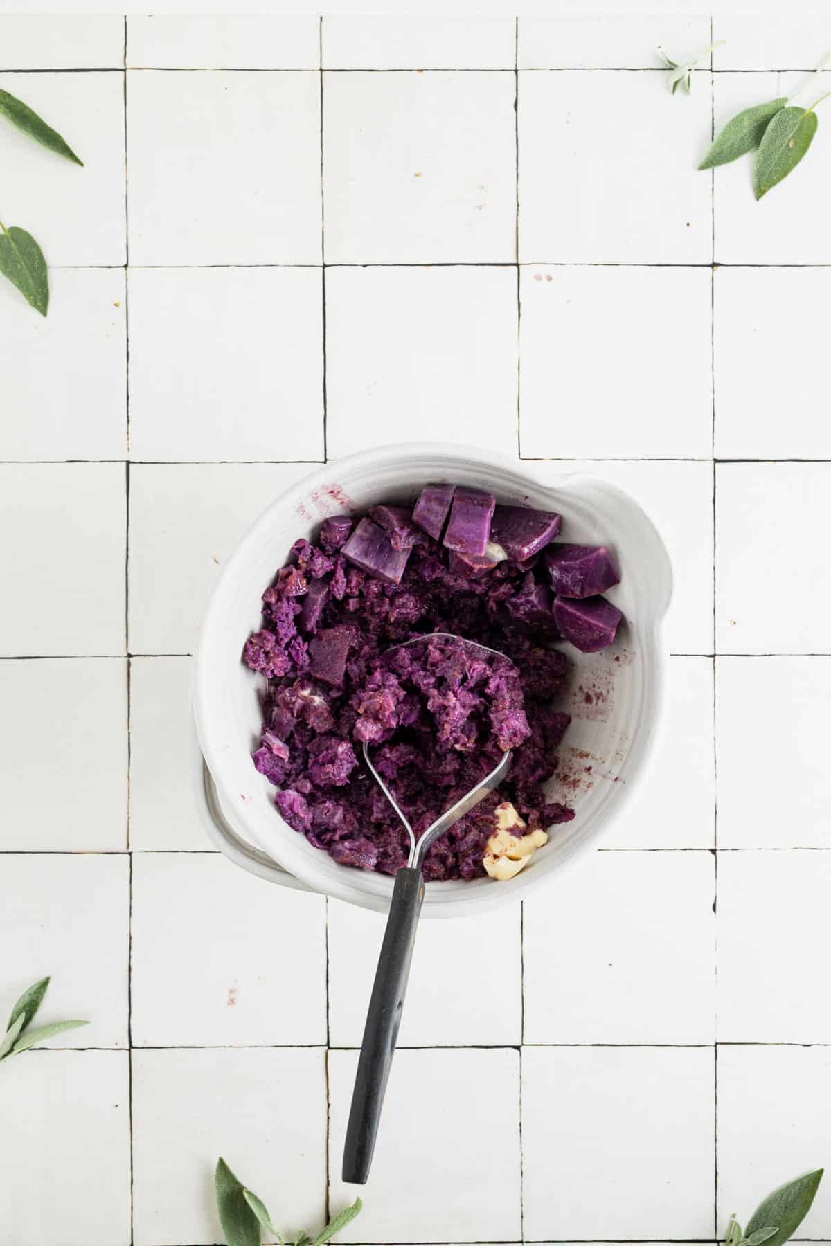 Mashing the ingredients for homemade vegan sweet potatoes.