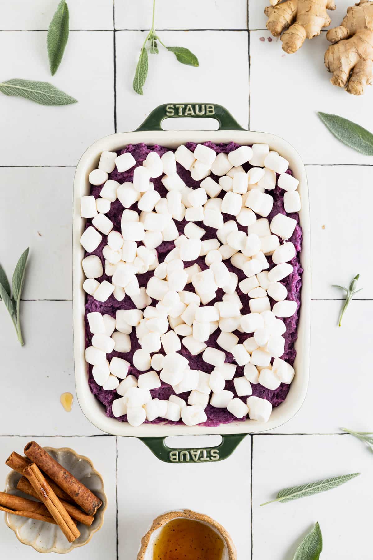 Smooth sweet potato casserole spread out in a baking dish with marshmallows on top.