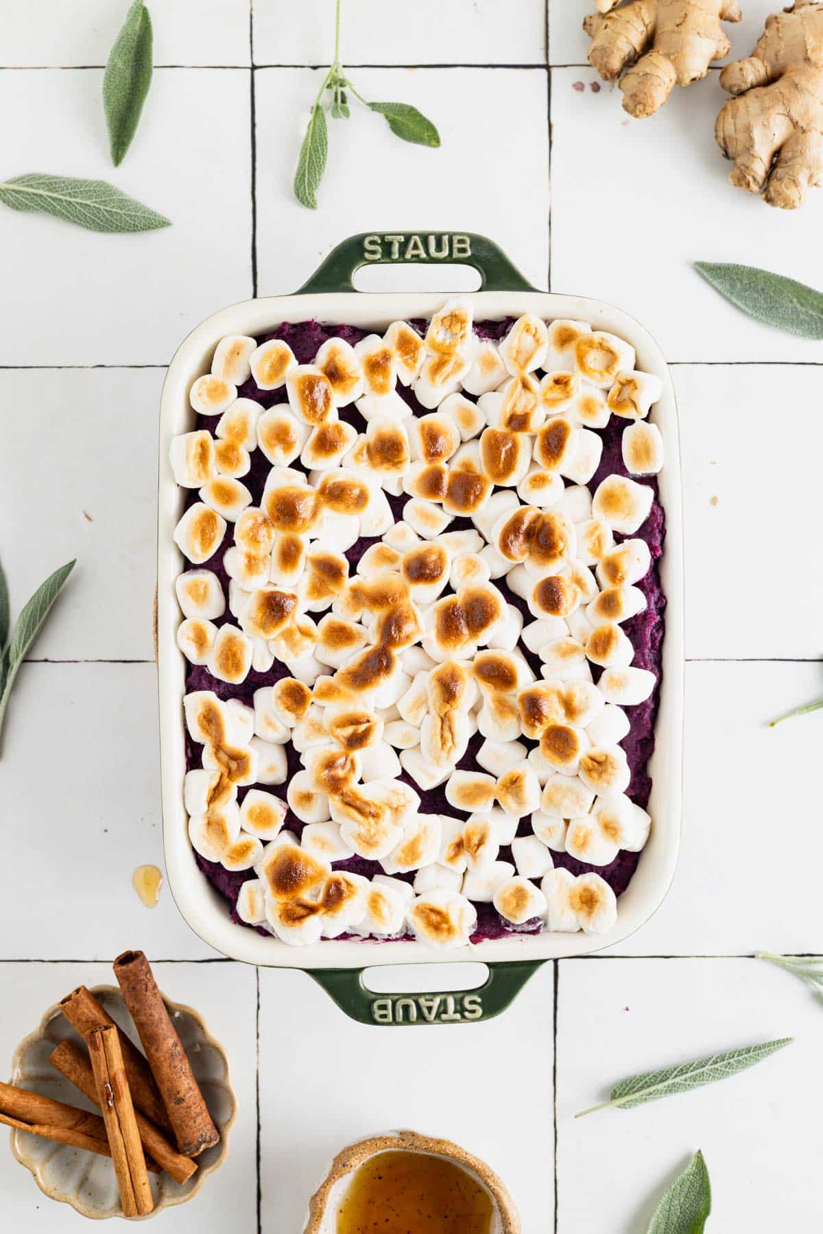 Smooth sweet potato casserole spread out in a baking dish with golden marshmallows on top.