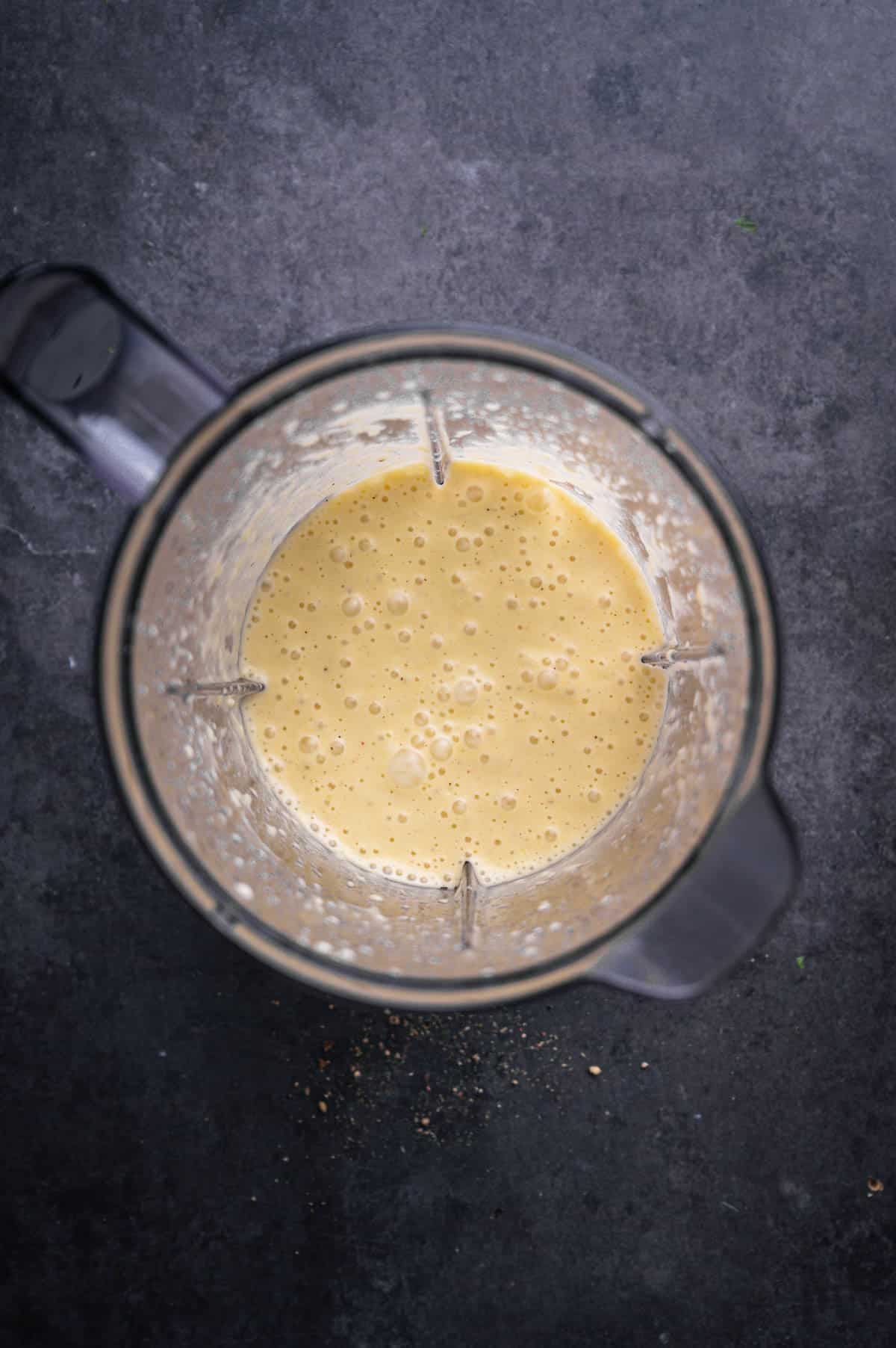 Ingredients for sweet onion and citrus dressing in a blender, blended up.