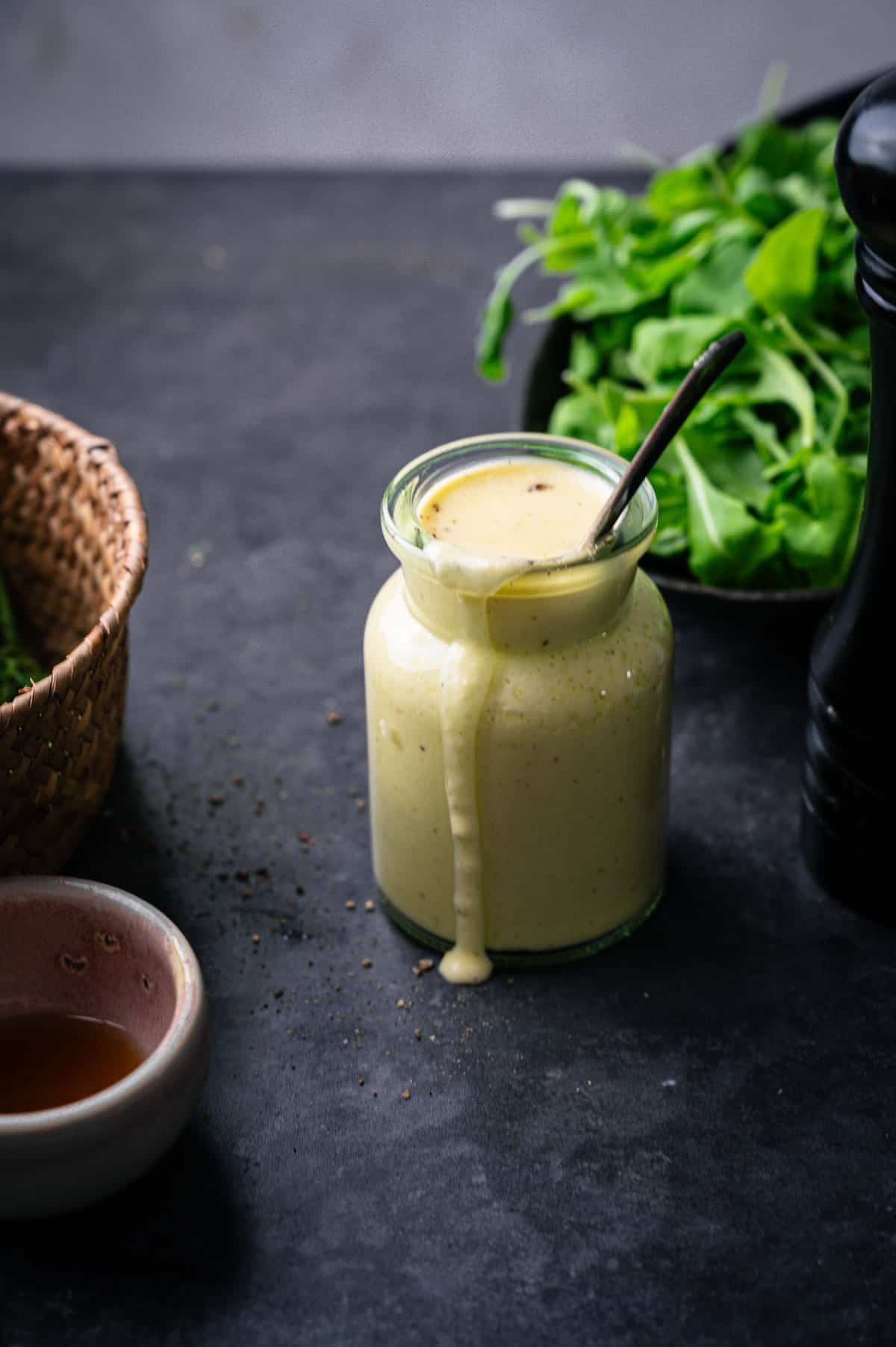 Citrus sweet onion dressing in a glass jar with it dribbling over the side.