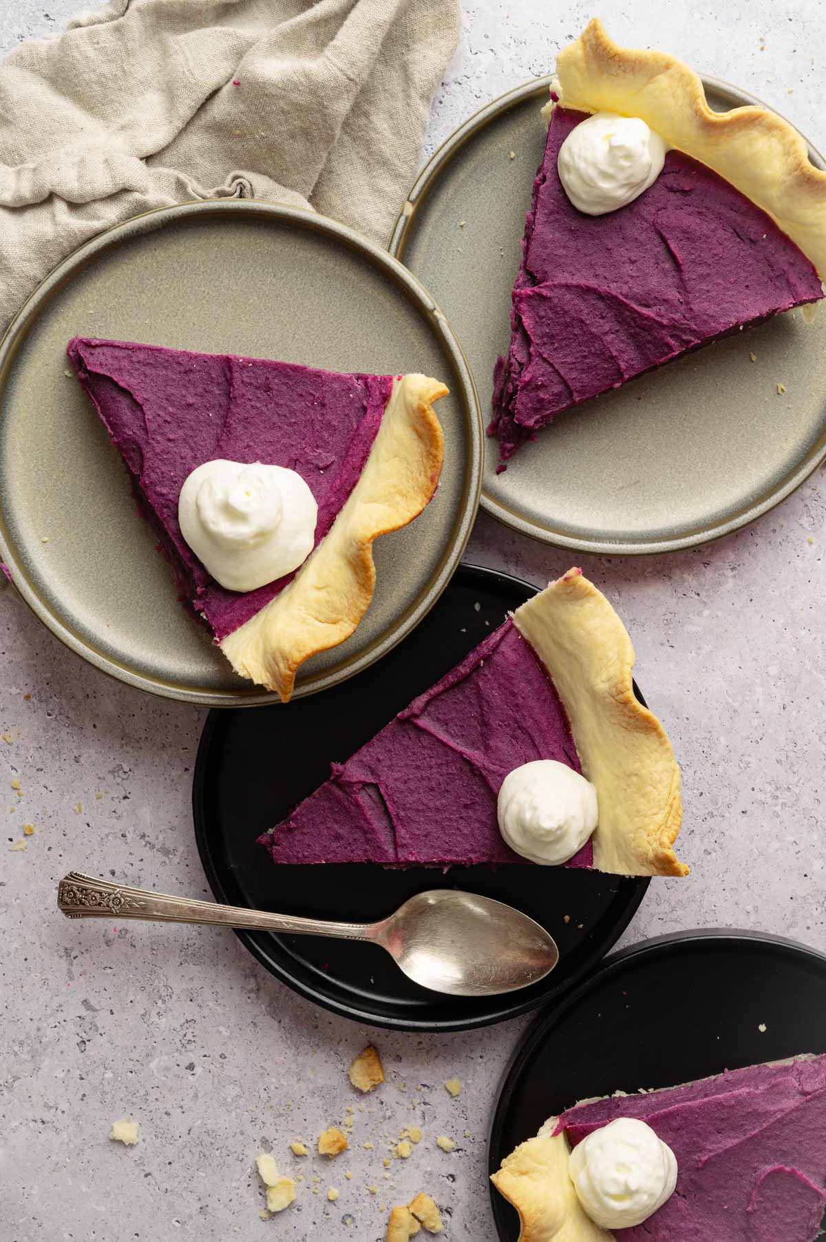 Homemade vegan sweet potato pie slices on plates with whipped cream.