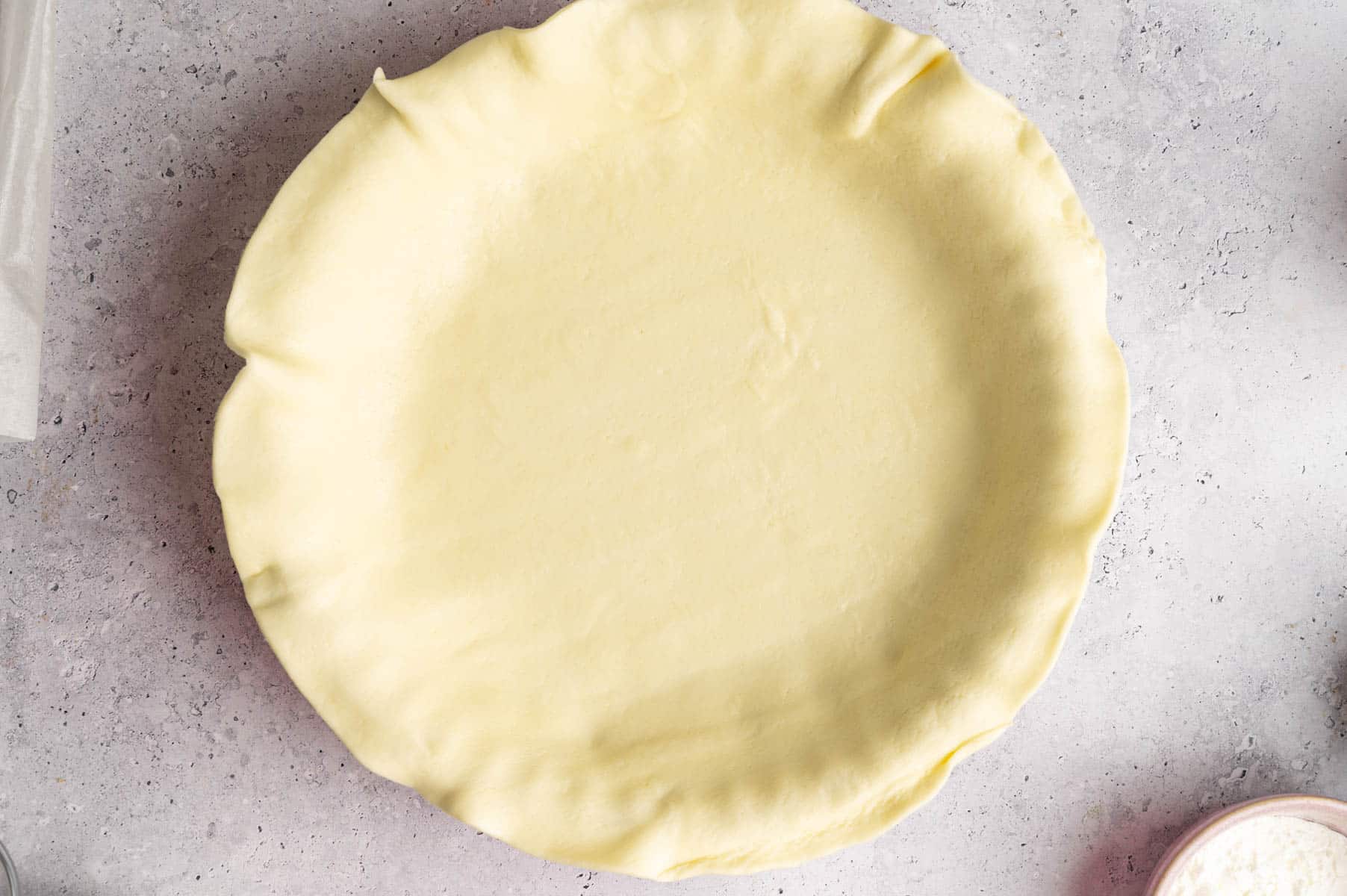 Lining a pie pan with pie dough.