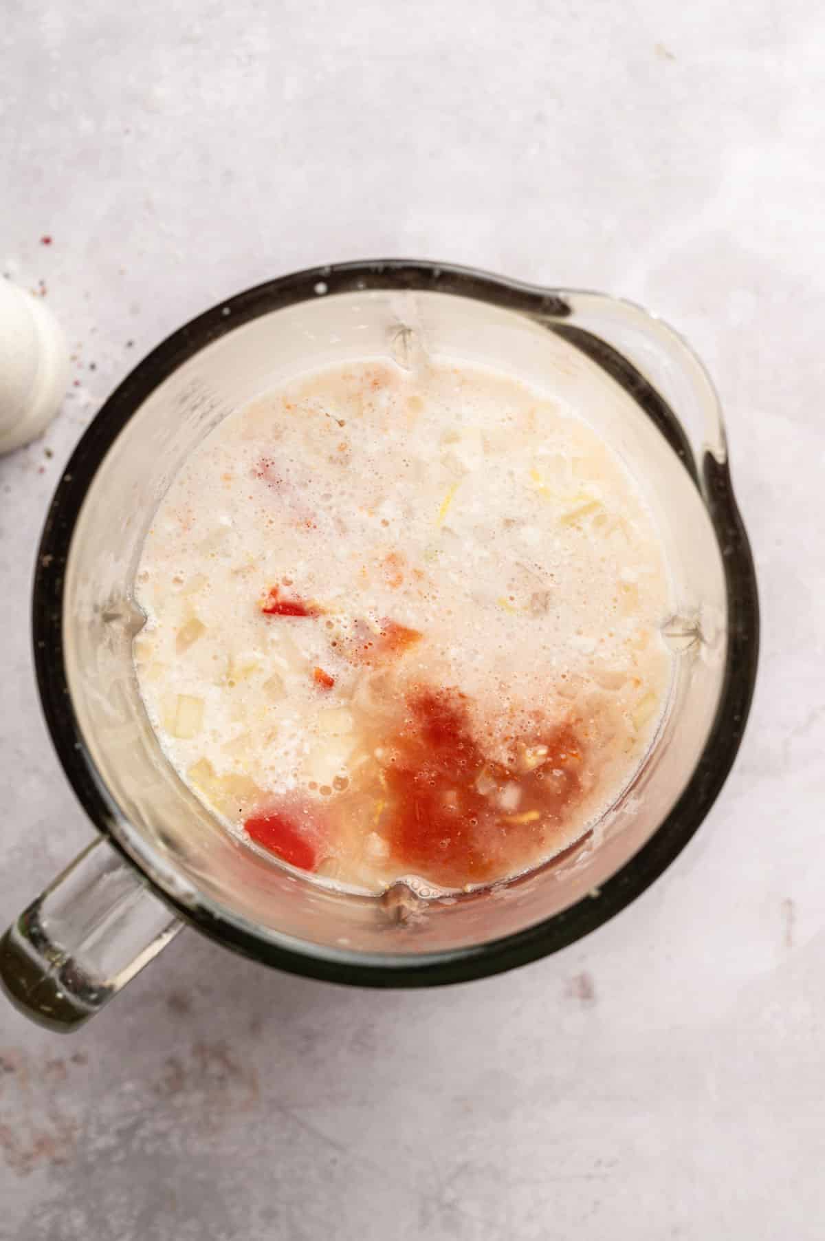 Adding coconut milk to the blender.