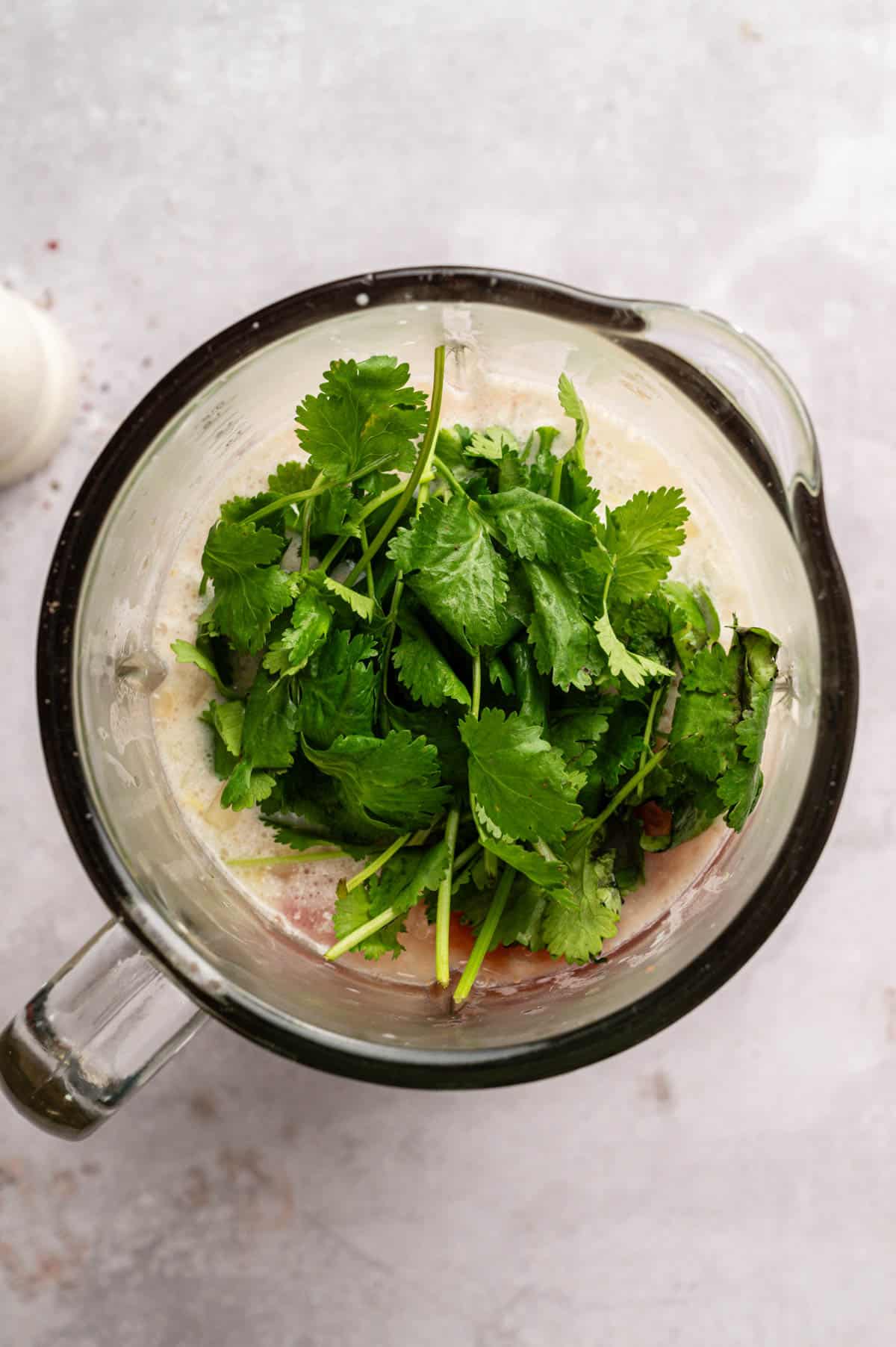 Adding cilantro to the blender.