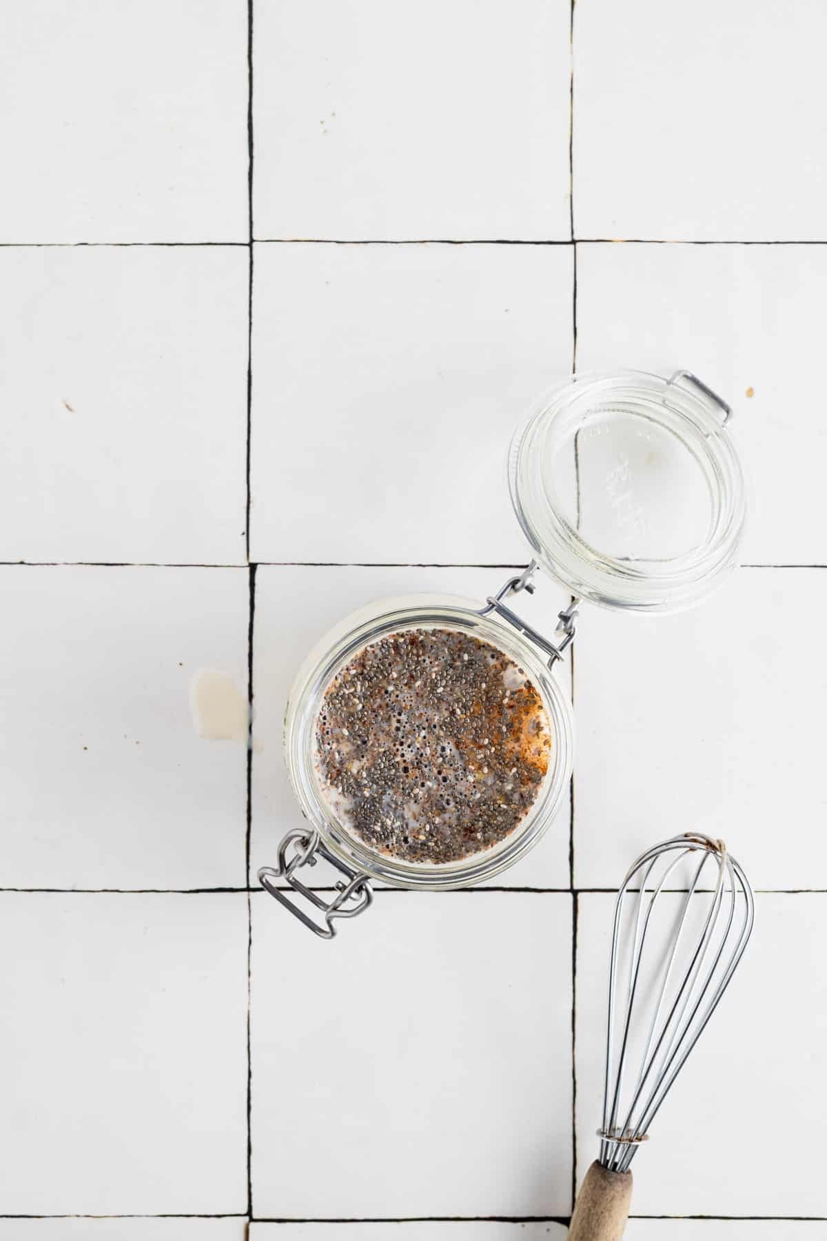 All ingredients for flax and chia seed pudding in a clear glass jar.