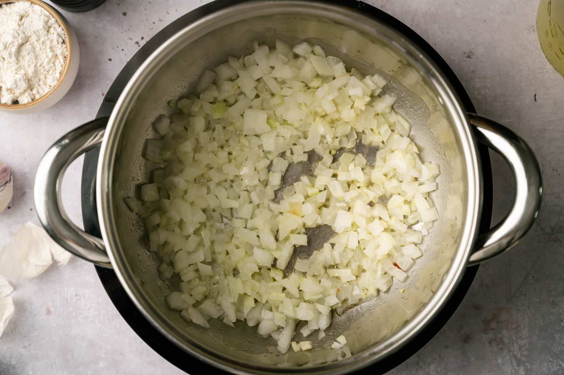 Diced onions sautéing in a cooking pot.