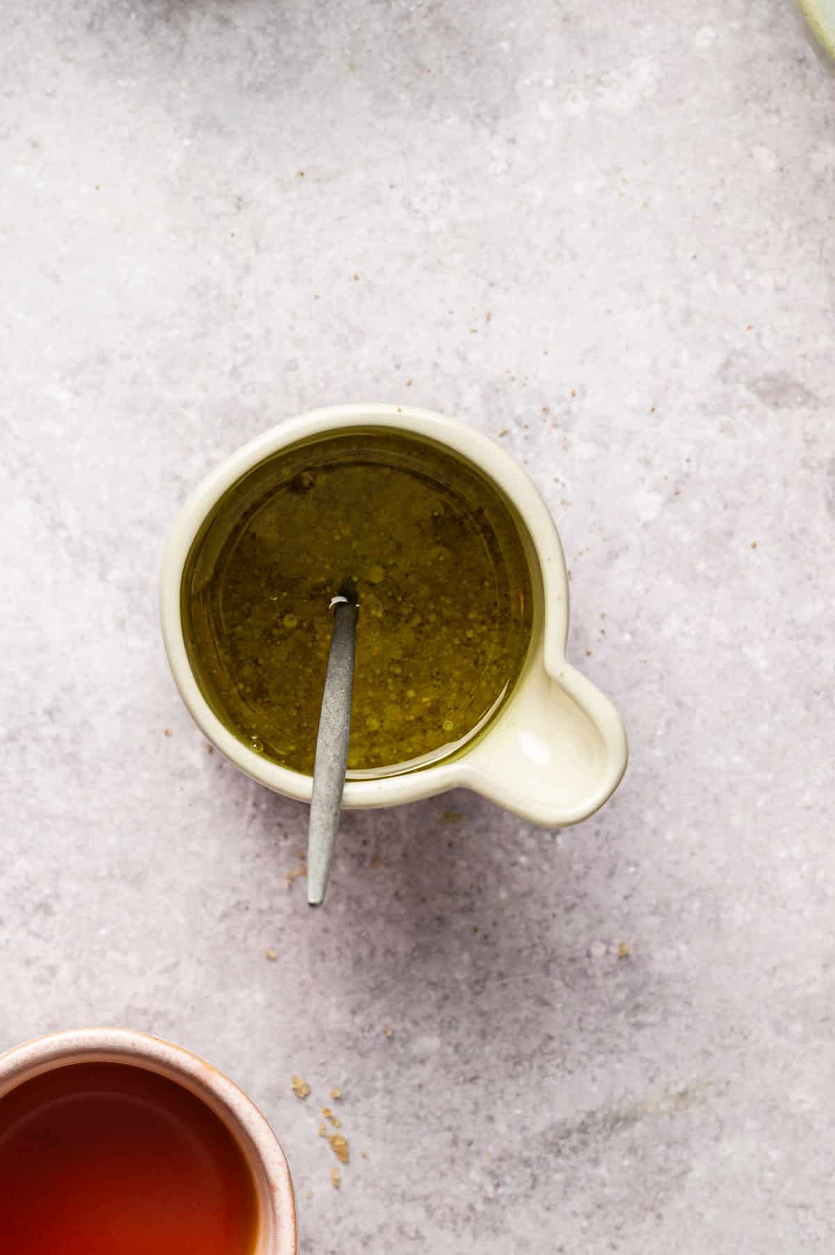 Ingredients for maple Dijon vinaigrette in a small carafe.