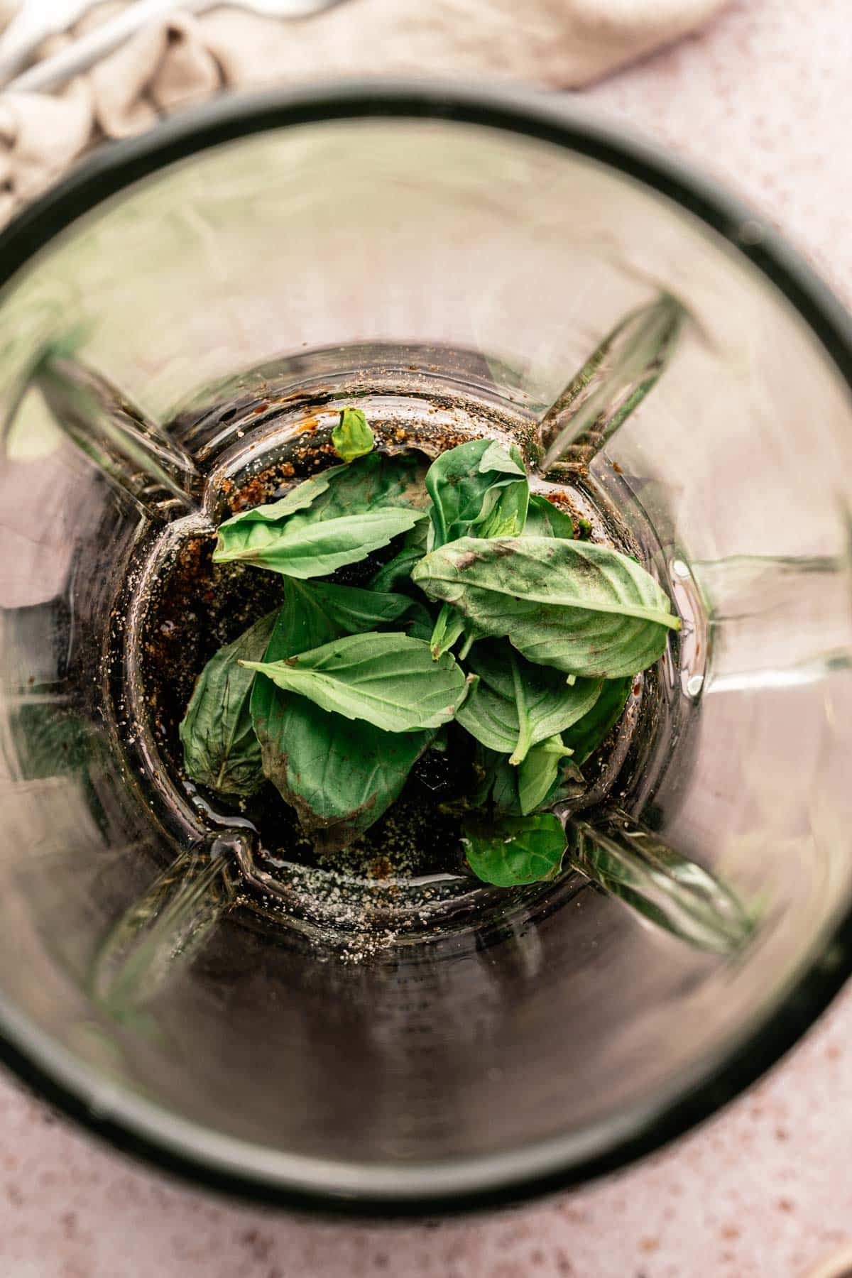 Fresh spinach added to a blender to make homemade salad dressing.