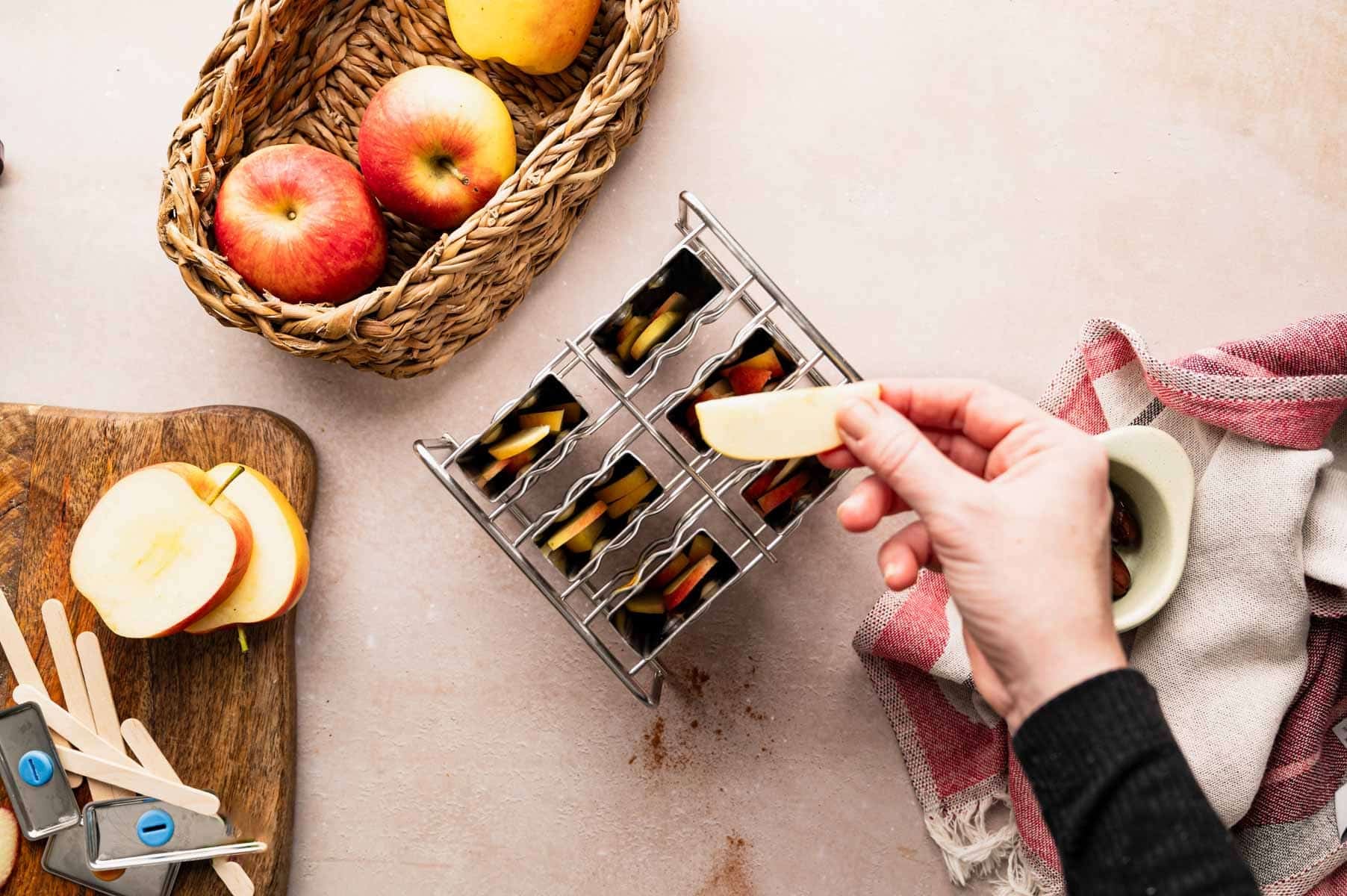 Adding apples to popsicles mold.